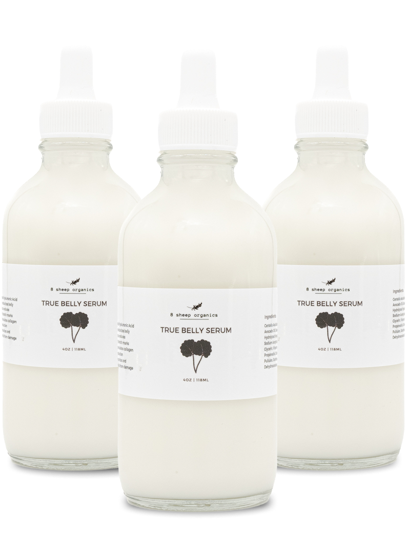 Three clear glass bottles filled with a white liquid labeled True Belly Serum from 8 Sheas Organics, each with a white dropper cap and simple white label featuring black text and a plant illustration.