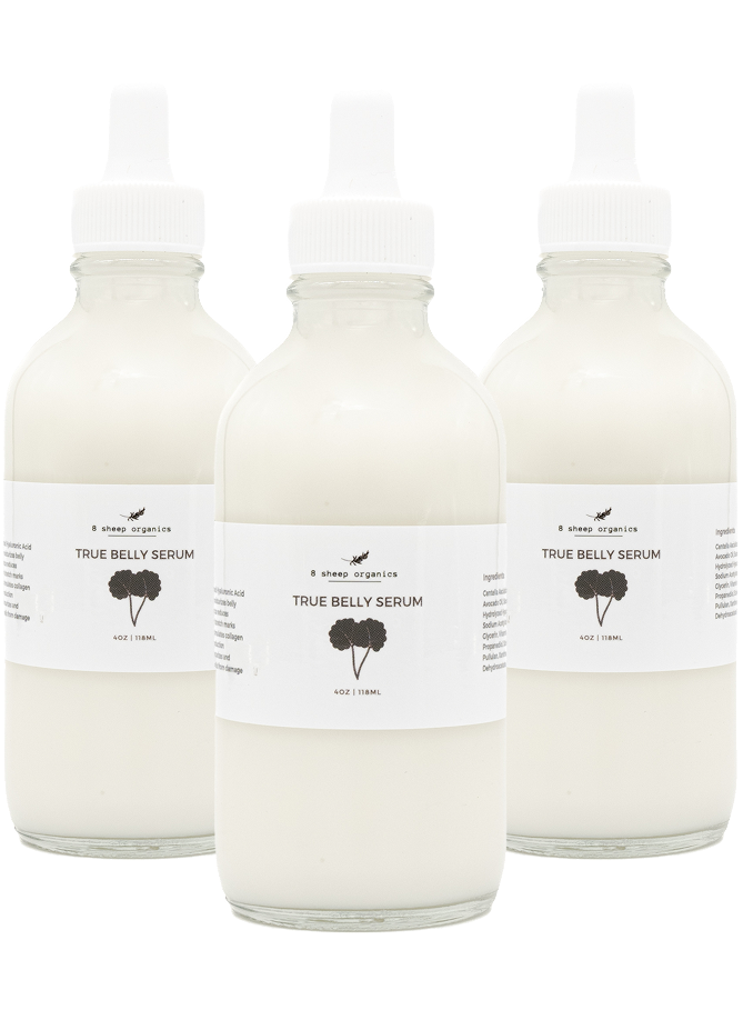 Three clear glass bottles filled with white liquid labeled Shea Organics True Belly Serum with black text and a simple plant graphic on each white label, displayed against a white background.