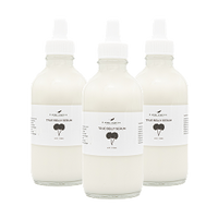 Three clear glass dropper bottles filled with a milky white liquid, labeled True Cream Serum with a minimalist design and a small graphic of a plant leaf on each label.